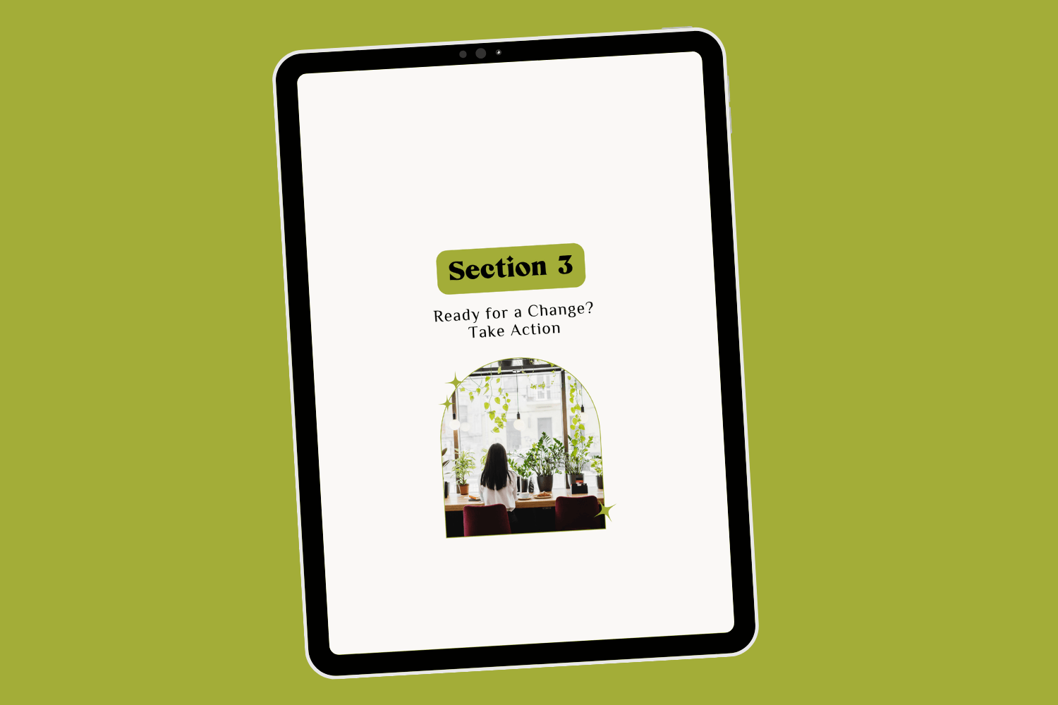 Tablet with page of ebook career transition guide Career Clarity Workbook by Lucy Todd Coaching. The page reads "Section 3: Ready for a Change? Take Action!" and features a photo of a young woman with long black hair sitting at a bar-height countertop near the large window of a bright coffee shop, with many indoor plants nearby